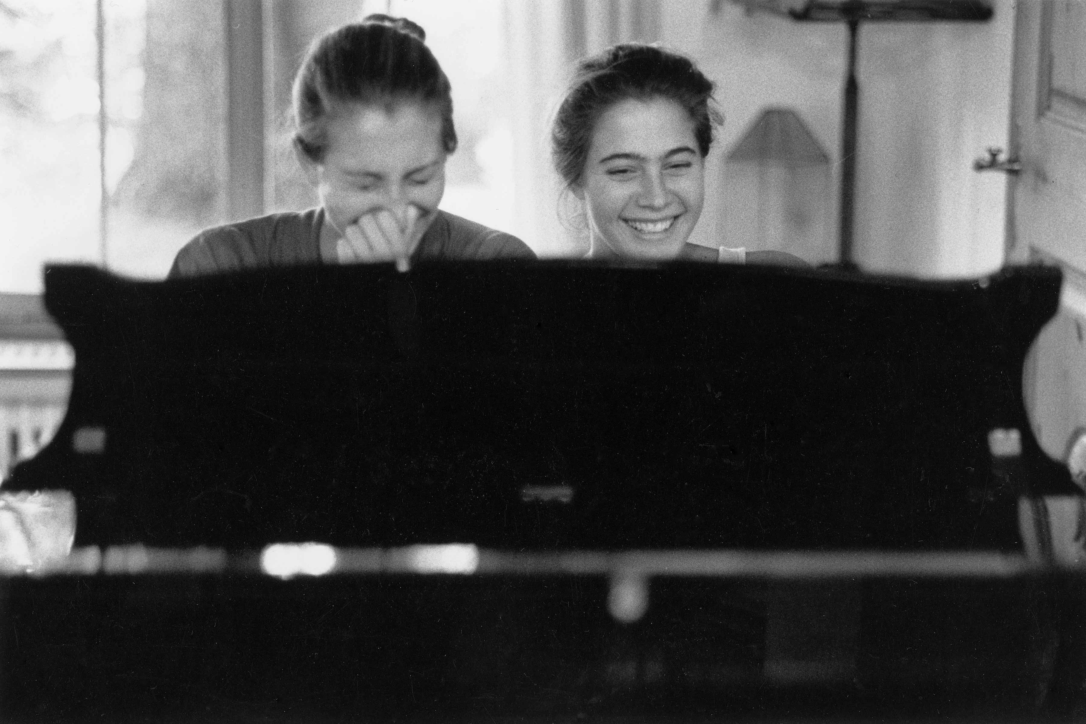 Eva 15 years old playing piano with her sister and laughing together